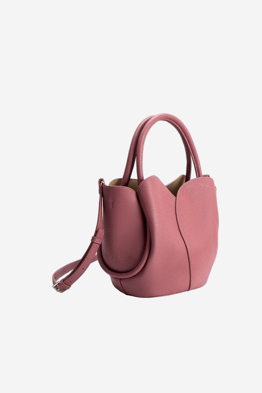Pink handbag with a strap on a white background